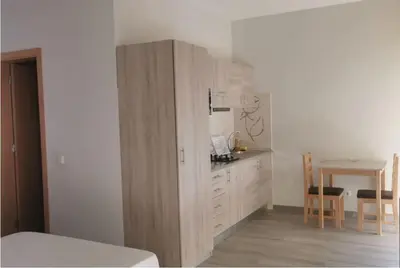 a room with a kitchen with a counter and a table at Ellen Apartamento T0 - Inforsal in Espargos