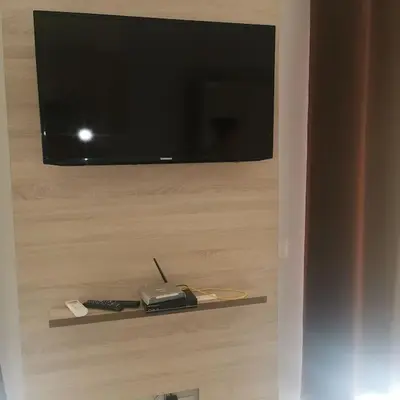 a flat screen tv on a wall with a remote control at Ellen Apartamento T0 - Inforsal in Espargos