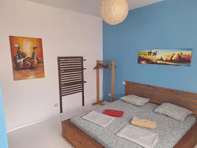 a bedroom with a bed and a painting on the wall at Útulný apartmán na Praia de Chaves, Boa Vista in Sal Rei