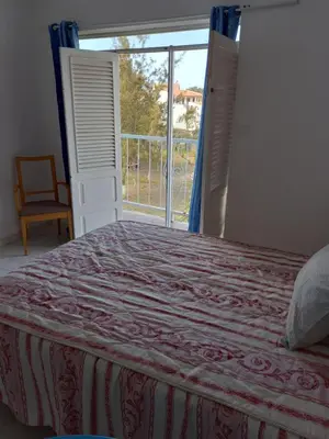 a bedroom with a bed and a large window at Hotel Sol Marina in Tarrafal