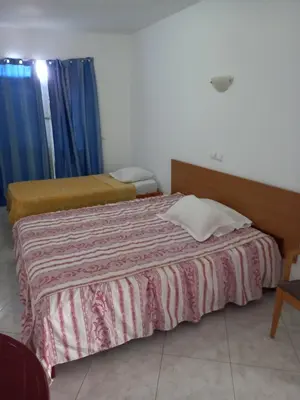 a hotel room with two beds and a table at Hotel Sol Marina in Tarrafal