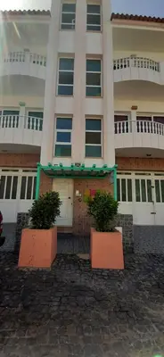 a building with two potted plants in front of it at Atlantic Sal Hostel in Santa Maria