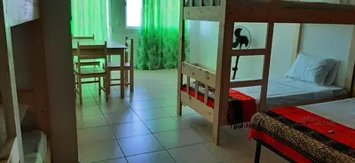 a bedroom with a bunk bed and a dining room at Atlantic Sal Hostel in Santa Maria