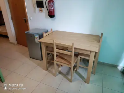 a wooden table and chair next to a trash can at Atlantic Sal Hostel in Santa Maria