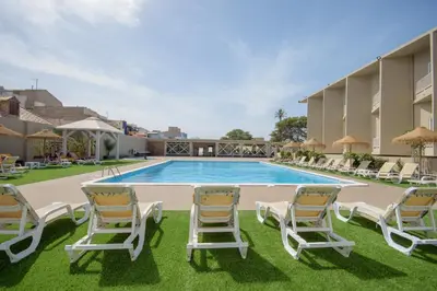a pool at the resort with lounge chairs at Oasis Porto Grande in Mindelo