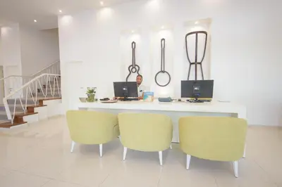 a man sitting at a table with two laptops at Oasis Porto Grande in Mindelo