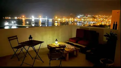 a living room with a couch and a table and chairs at Amwilla Guesthouse Quarto WC privativo Elsa in Mindelo