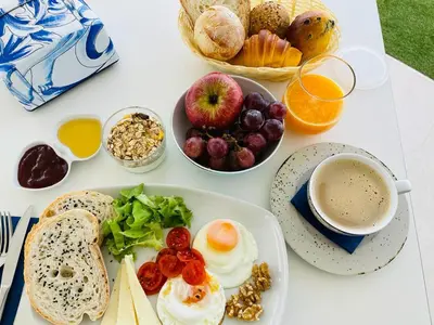 a white table with breakfast foods and a cup of coffee at DESIGN SUITES Boutique Hotel - Adults Only in Santa Maria