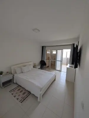 a white bedroom with a bed and a television at Casa Relaxod in Santa Maria