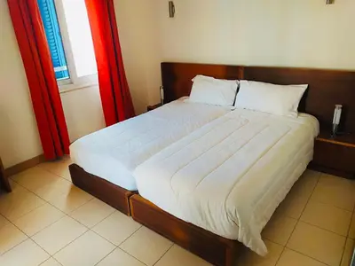 a bedroom with a large bed with white sheets and a window at Apartamento Privado Vila Verde in Santa Maria