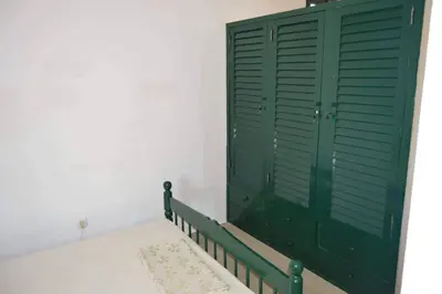a green cabinet in a room with a rug at Apartamento T1 Mobilado com Wi-Fi in Praia