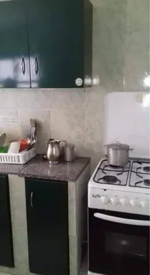 a kitchen with a stove with pots and pans on it at Apartamento T1 Mobilado com Wi-Fi in Praia