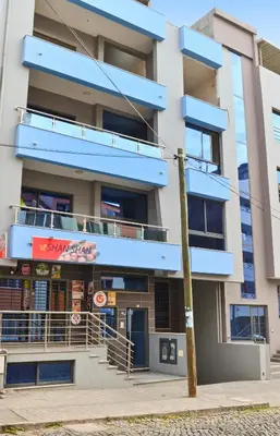 an apartment building with blue balconies on a street at AP2B Praia in Praia