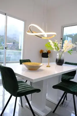 a white table with green chairs and a vase with flowers at VILLA NAYELI Luxury and Simplicity in Órgãos