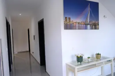 a white hallway with a table and a bridge painting on the wall at VILLA NAYELI Luxury and Simplicity in Órgãos