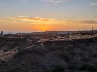 an empty field with the sun setting in the horizon at Appartement Cara do Mar in Praia