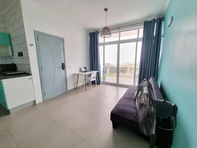 a living room with a couch and a large window at Appartement Cara do Mar in Praia