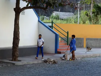 two people standing on a sidewalk with two dogs at Kasa d'Vizin in Paul