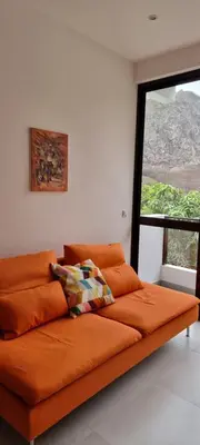 an orange couch in a room with a window at Kasa d'Vizin in Paul