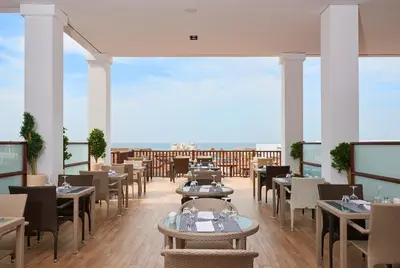 a restaurant with tables and chairs on a balcony at Melia Llana Beach Resort & Spa - Adults Only - All Inclusive in Santa Maria