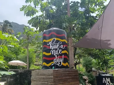 a vase with a sign that reads a make a nice day at Tiny House Ribeira Principal in Mato Correia