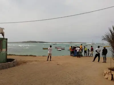 a group of people standing on a beach looking at the water at Leben am Atlantik hautnah spüren in Sal Rei