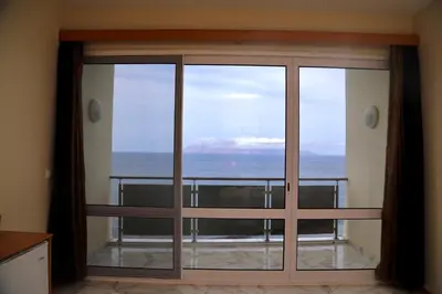 a room with a view of the ocean through a sliding glass door at Cruzeiro Guest House in São Filipe