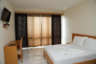 a bedroom with a bed and a desk and a window at Cruzeiro Guest House in São Filipe