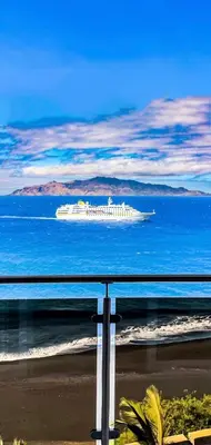 a cruise ship in the ocean near the beach at Cruzeiro Guest House in São Filipe
