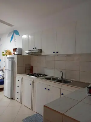 a kitchen with white cabinets and a sink and a refrigerator at AMA Apartament Ponta Preta in Calheta Do Maio