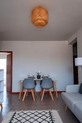 a living room with a table and three chairs at Brand New Chic Appt in Mindelo at Great Rates in Mindelo