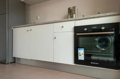 a kitchen with white cabinets and a microwave at Brand New Chic Appt in Mindelo at Great Rates in Mindelo