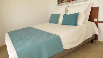 a bed with two blue pillows on top of it at Ocean Roof in Santa Maria