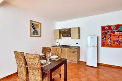 a dining room with a table and chairs and a kitchen at Patio Antigo Residence in Santa Maria
