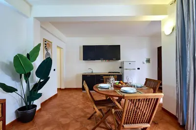 a dining room with a table and chairs and a kitchen at Patio Antigo Residence in Santa Maria