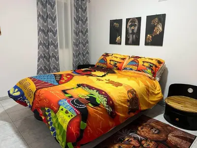 a bedroom with a bed with a colorful comforter at Apartamento Os Bidons in Praia
