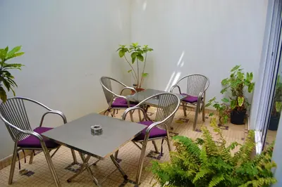 a group of tables and chairs in a room with plants at Sol Hotel in Praia
