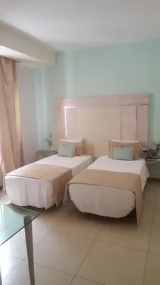 two beds sitting next to each other in a room at Sol Hotel in Praia