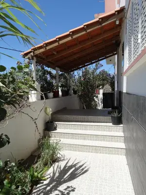 a patio with a wooden pergola on a house at Yria Residencial in Porto Novo