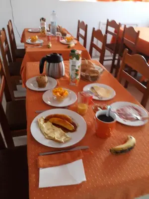 a long table with plates of breakfast food on it at Yria Residencial in Porto Novo