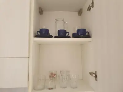 a shelf with cups and glasses on it at Santa Maria Borgo Verde Apartment T2 in Santa Maria