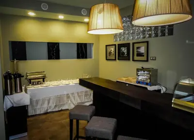 a dining room with a table and two stools at Hotel Praia Confort in Praia
