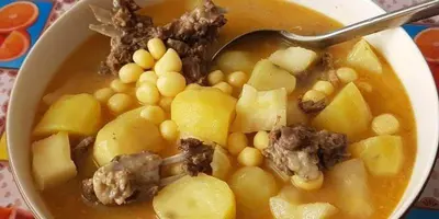 a bowl of soup with meat and beans and a spoon at Pam de Terra in Palha Carga