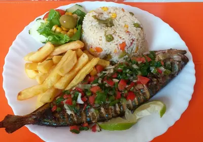 a plate of food with rice and fish and french fries at Pam de Terra in Palha Carga