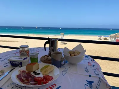 a table with a plate of food on the beach at Beach Rotxa in Vila do Maio