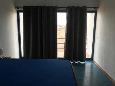a room with a blue couch in front of a window at Beach Rotxa in Vila do Maio