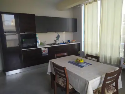 a kitchen with a table with chairs and a kitchen with a counter at Apartamento T2 em Sal Rei - Boavista in Sal Rei