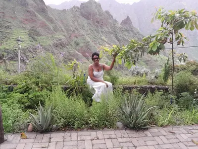 a man sitting on a ledge in front of a mountain at Pousada Rural Simpatia in Caculi