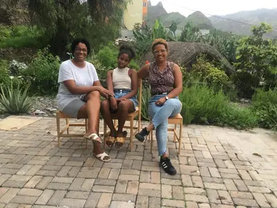 three women sitting on chairs in a garden at Pousada Rural Simpatia in Caculi
