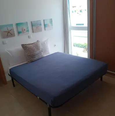 a blue bed in a room with a window at Lovely - Luxury 2 Bedrooms 500m from the Beach in Santa Maria